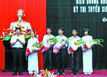 Đồng chí Nguyễn Hữu Hoài, Phó Bí thư Tỉnh ủy, Chủ tịch UBND tỉnh tặng hoa cho các thủ khoa. Ảnh: H.M