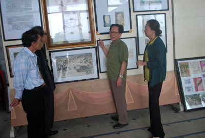 Đại tá - họa sĩ Lê Duy Ứng bên những bức tranh tại gian trưng bày triển lãm. Ảnh: P.H