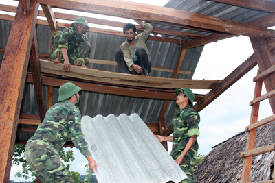 Cán bộ chiến sĩ Đồn Biên phòng Làng Ho đang dựng  nhà cho bà con.  Ảnh: Minh Lợi
