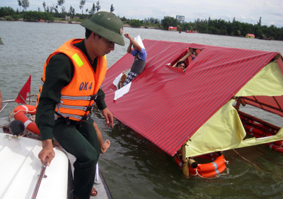 Lực lượng cứu hộ, cứu nạn dùng ca nô tiếp cận những gia đình bị nước cuốn trôi trên sông Nhật Lệ 