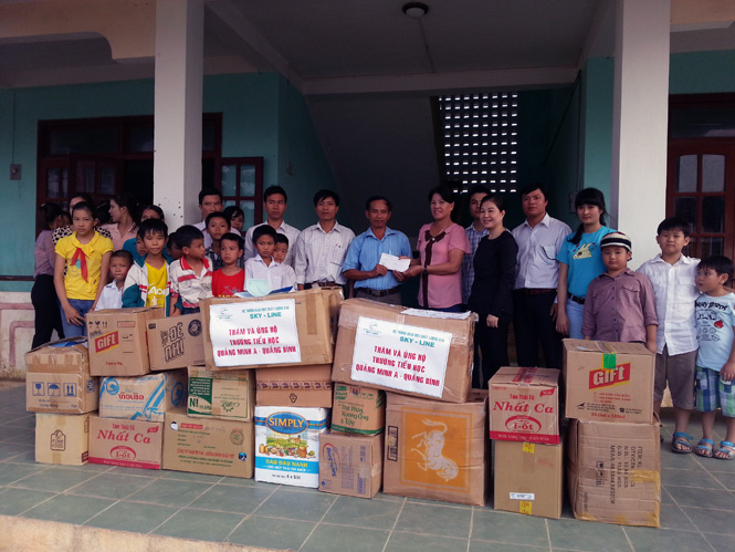 Đại diện lãnh đạo Hệ thống giáo dục chất lượng cao Sky-Line trao quà cho các em học sinh trường Tiểu học Quảng Minh.