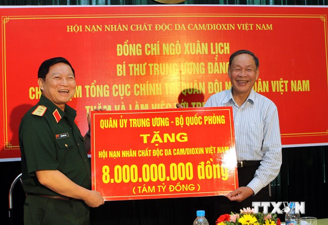 Thượng tướng Ngô Xuân Lịch trao tượng trưng số tiền 8 tỷ đồng cho đại diện lãnh đạo Hội Nạn nhân chất độc da cam/dioxin Việt Nam. (Ảnh: Nguyễn Thủy-TTXVN)
