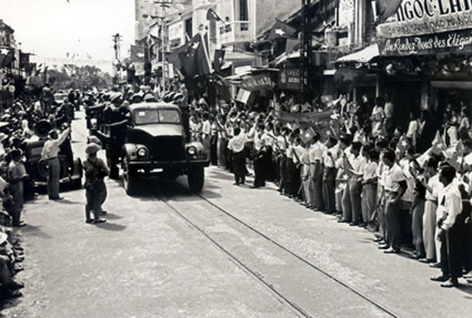Nhân dân phất cờ, tung hoa, reo mừng, chào đón đoàn quân tiến về giải phóng Thủ đô ngày 10-10-1954. Ảnh tư liệu