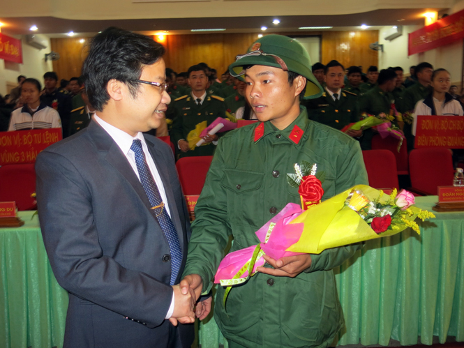 Đồng chí Trưởng ban Tuyên giáo Tỉnh ủy tặng hoa và căn dặn, động viên tân binh huyện Minh Hóa.