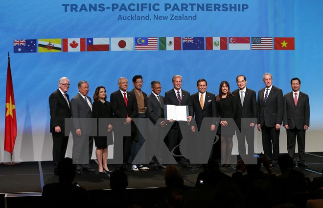 12 Bộ trưởng Thương mại và Kinh tế các nước thành viên tham gia TPP chụp ảnh chung sau khi ký kết văn kiện diễn ra sáng 4-2 ở New Zealand. (Nguồn: AFP/TTXVN)