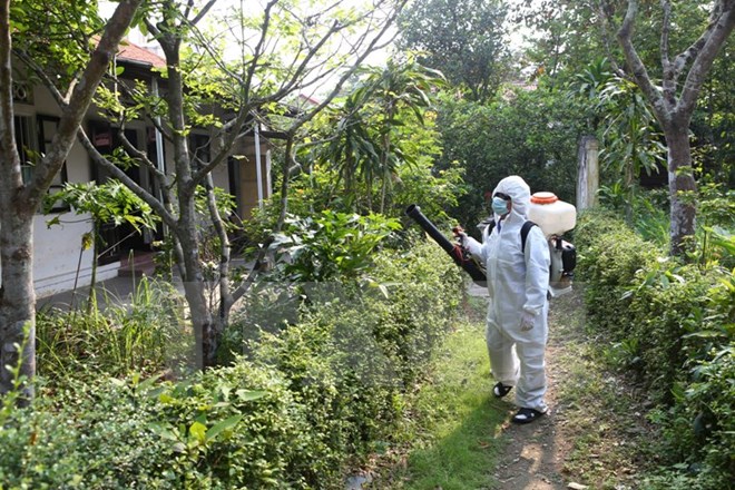 Cán bộ Trung tâm Y tế dự phòng phun thuốc diệt muỗi phòng chống dịch bệnh. (Ảnh: Hồ Cầu/TTXVN)