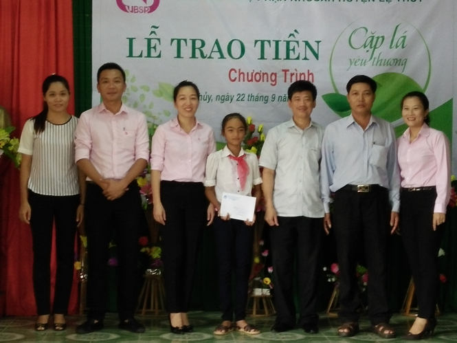 Đại diện lãnh đạo Ngân hàng chính sách xã hội Quảng Bình trao quà chương trình “Cặp lá yêu thương” cho em Kro Xa.
