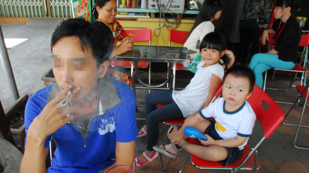 Trẻ em, phụ nữ thường phải hít khói thuốc lá thụ động tại nhiều nơi công cộng - Ảnh: Hoàng Thạch Vân
