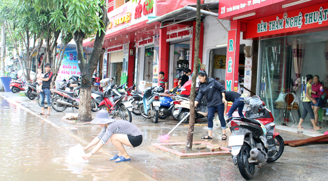 Người dân hai bên đường Trần Hưng Đạo làm vệ sinh nhà cửa sau trận lũ