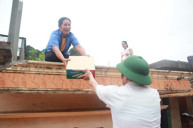 Người dân phải trèo lên mái nhà để tránh lũ.