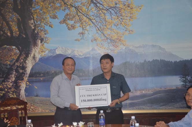Đồng chí Trần Văn Tuân, Ủy viên Ban Thường vụ Tỉnh ủy, Chủ tịch Ủy ban MTTQVN tỉnh trao 150 triệu đồng tiền hỗ trợ khẩn cấp cho huyện Bố Trạch. 