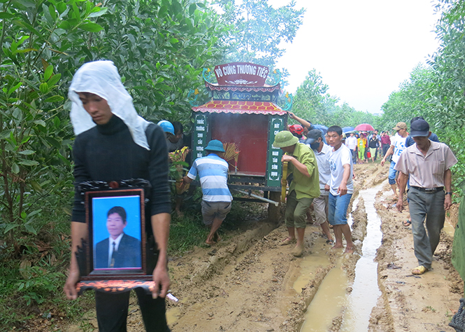 Lễ đưa tang anh Thưởng trên con đường vẫn còn lầy lội sau mưa lũ.