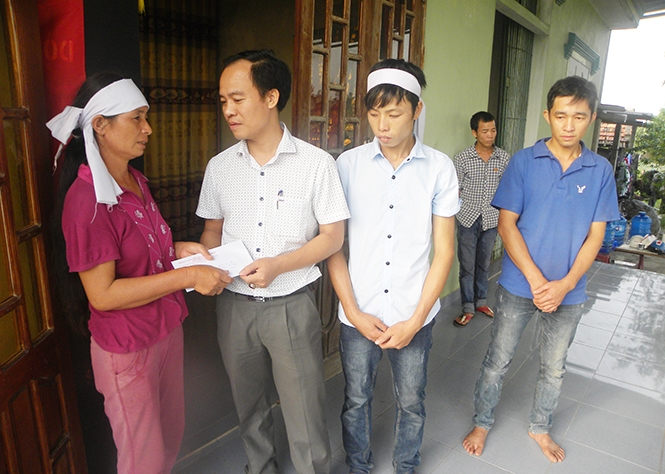 Đại diện Công ty CP Vận tải Phú Hoàng trao tiền phúng viếng cho gia đình có người thiệt mạng do lũ lụt ở thôn 7, xã Lý Trạch (huyện Bố Trạch).