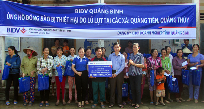 Đồng chí Lê Công Hữu, TUV, Bí thư Đảng ủy Khối Doanh nghiệp và đại diện Ngân hàng BIDV Quảng Bình trao quà hỗ trợ bà con xã Quảng Thủy.