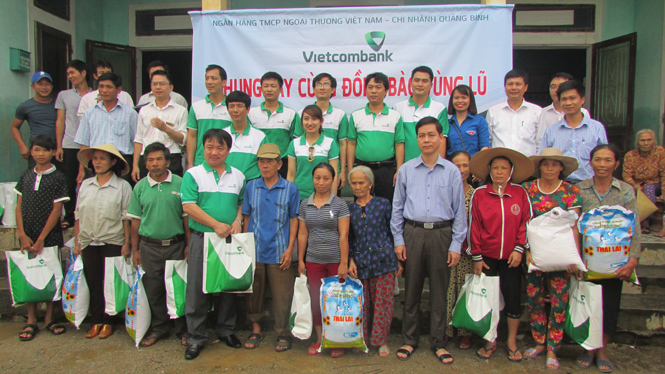 Đồng chí Lê Công Hữu, TUV, Bí thư Đảng ủy Khối Doanh nghiệp và đại diện Ngân hàng Vietcombank trao quà hỗ trợ bà con xã An Thủy.