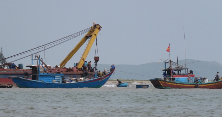 Anh Lê Xuân Phúc và ngư dân địa phương đang tham gia trục vớt tàu cá bị chìm 	 	