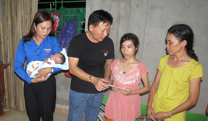   Ông Nguyễn Thanh Tú, đại diện lãnh đạo Cty Vinamilk trao số tiền hỗ trợ 10 triệu đồng cho chị Hoàng Thị Hiền (xã Quảng Minh, thị xã Ba Đồn)