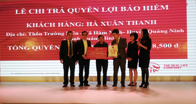 Đại diện lãnh đạo AIA Việt Nam trao tiền chi trả cho gia đình của anh Hà Xuân Thanh, xã Hàm Ninh, huyện Quảng Ninh.