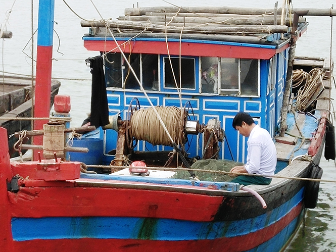 Anh Nguyễn Xuân Sỹ (Bảo Ninh, TP. Đồng Hới) tranh thủ vá lại lưới chuẩn bị cho chuyến ra khơi ngày cuối năm.