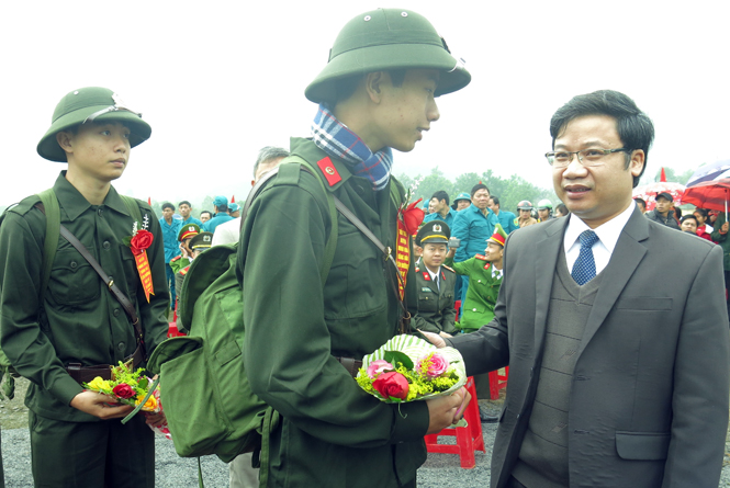  Đồng chí Cao Văn Định, Uỷ viên Ban Thường vụ Tỉnh ủy, Trưởng ban Tuyên giáo Tỉnh ủy tặng hoa và căn dặn, động viên tân binh huyện Minh Hóa.                
