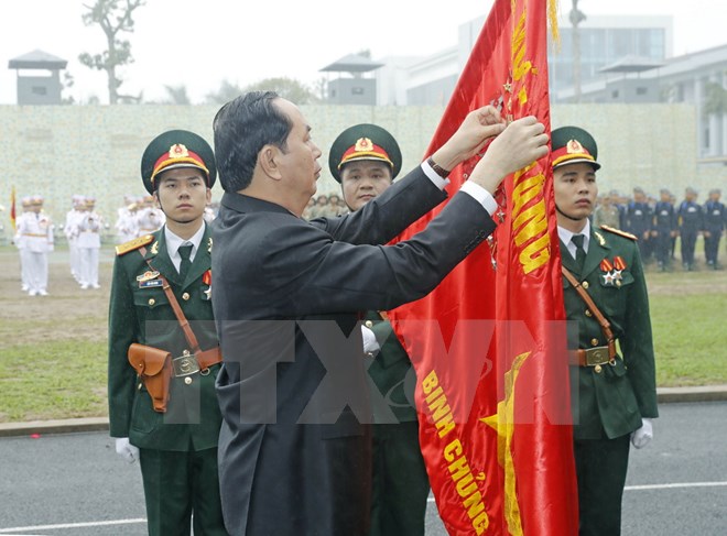 Chủ tịch nước Trần Đại Quang gắn Huân chương Quân công hạng Nhất lên lá cờ truyền thống của Bộ Tư lệnh Binh chủng Đặc công. (Ảnh: Nhan Sáng/TTXVN)