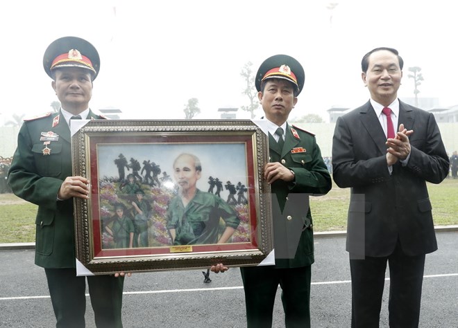 Chủ tịch nước Trần Đại Quang trao tặng bức tranh Bác vẫn cùng chúng cháu hành quân cho Bộ Tư lệnh Binh chủng Đặc công. (Ảnh: Nhan Sáng/TTXVN)