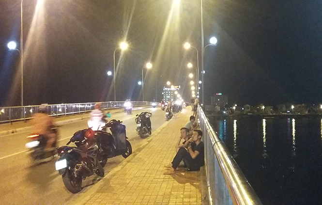 Các bạn trẻ dừng, đậu xe máy ngay trên cầu Nhật Lệ để hóng mát.