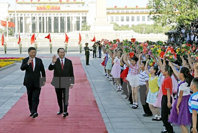 Chủ tịch nước Trung Quốc Tập Cận Bình và Chủ tịch nước Trần Đại Quang vẫy chào các cháu thiếu nhi tại lễ đón. (Ảnh: Nhan Sáng/TTXVN)