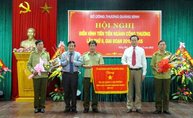Đồng chí Nguyễn Xuân Quang, Ủy viên Ban Thường vụ Tỉnh ủy, Phó Chủ tịch Thường trực UBND tỉnh trao cờ thi đua của UBND tỉnh cho Chi cục QLTT, đơn vị dẫn đầu phong trào thi đua toàn tỉnh năm 2014.