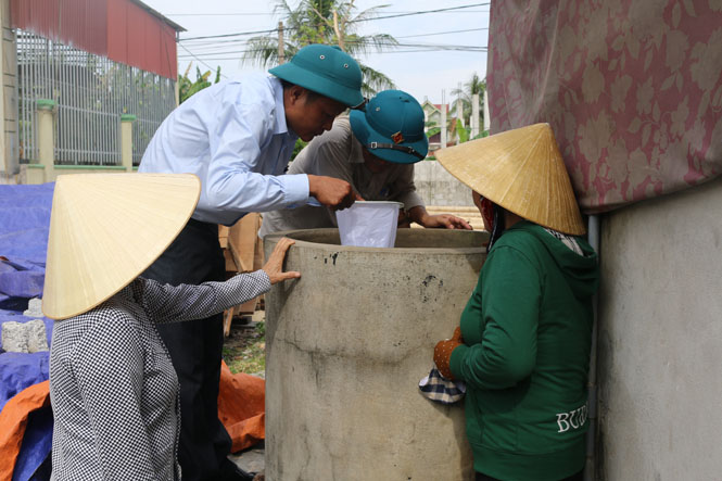Cán bộ y tế kiểm tra chất lượng nguồn nước tại gia đình các hộ dân ở xã Thanh Trạch.