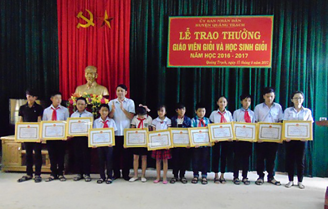 Đại diện lãnh đạo huyện Quảng Trạch trao thưởng cho các em học sinh đạt thành tích xuất sắc năm học 2016-2017.