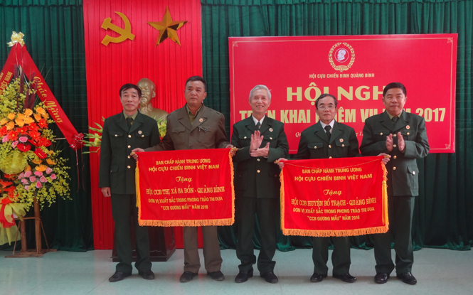 Đại diện Hội CCB tỉnh trao cờ thi đua xuất sắc của Trung ương Hội CCB Việt Nam cho Hội CCB thị xã Ba Đồn và Bố Trạch.