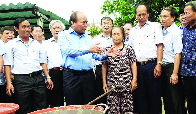 Ảnh 1: Thủ tướng Chính phủ Nguyễn Xuân Phúc thăm mô hình chế biến thủy sản tại xã Đức Trạch (Bố Trạch).