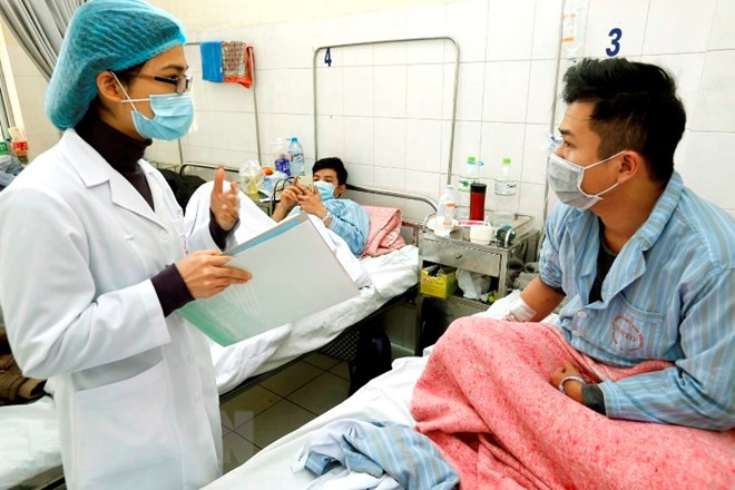 Cán bộ y tế tư vấn chăm sóc cho bệnh nhân mắc bệnh cúm tại bệnh viện Bệnh Nhiệt đới Trung ương. (Ảnh: Dương Ngọc/TTXVN)