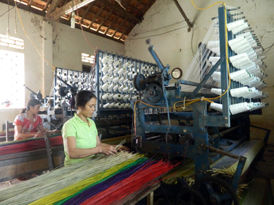 Xã viên HTX làng nghề chiếu cói An Xá đang dệt chiếu bằng máy công nghiệp.
