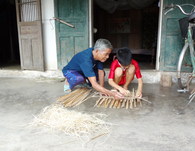 Ông Nguyễn Văn Ry đang dạy cháu cách đan lát.