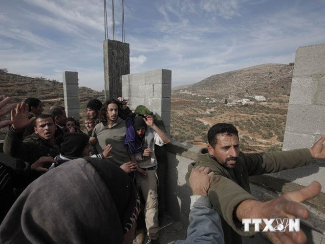 Người Palestine phản đối nhóm người Israel dựng các khu nhà tại khu vực Israel chiếm đóng ở khu Bờ Tây. (Nguồn: AFP/TTXVN)