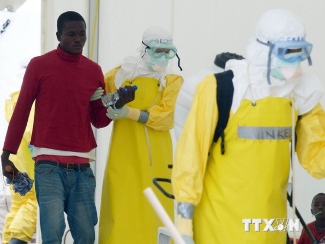 Nhân viên y tế trong trang phục bảo hộ giúp bệnh nhân nghi nhiễm Ebola tại bệnh viện Elwa ở Monrovia, Liberia ngày 7-9. (Nguồn: AFP/TTXVN)