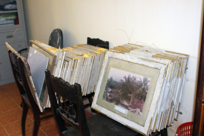 tranh ảnh, tư liệu xếp chồng lên nhau, nhiều tấm bị mục nát 