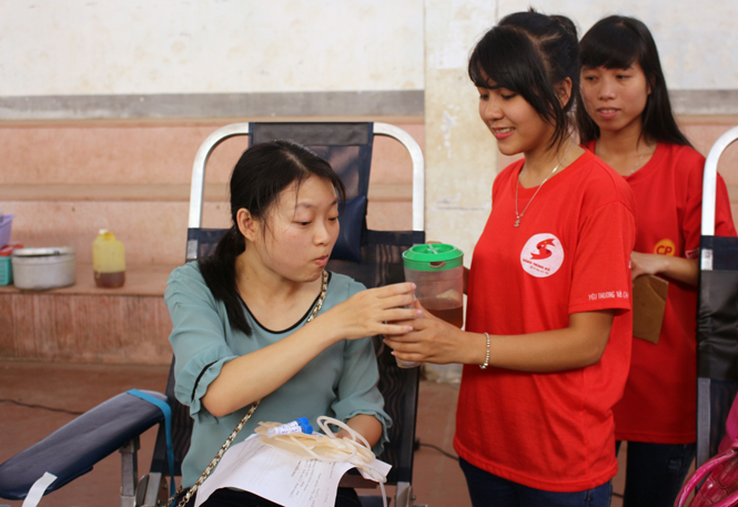 Các tình nguyện viên trong CLB Thanh niên vận động HMTN Quảng Bình phục vụ nước uống cho người tham gia hiến máu