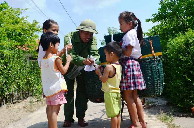 Trẻ con háo hức bên xe kẹo kéo của ông Lương