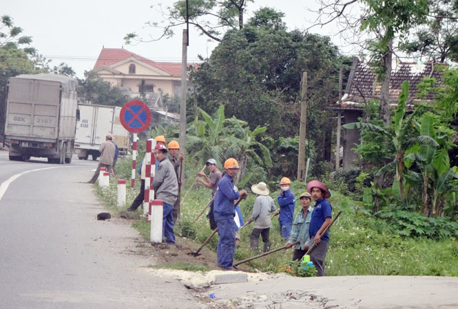 ẢNgười dân Lệ Thuỷ dọn dẹp vệ sinh trên tuyến Quốc lộ 1.