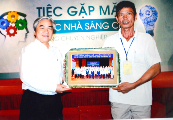 Bộ trưởng Bộ Khoa học và Công nghệ Nguyễn Quân trao quà cho anh Đặng Thanh Lâm.