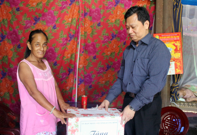 Đồng chí Phó Chủ tịch UBND tỉnh tặng quà cho nạn nhân CĐDC Nguyễn Thị Loan ở xã Tân Ninh, Quảng Ninh.
