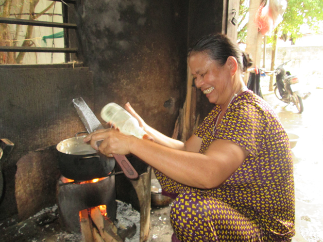  Bà Đính nhanh tay sát bột vào nồi cháo canh đang sôi.