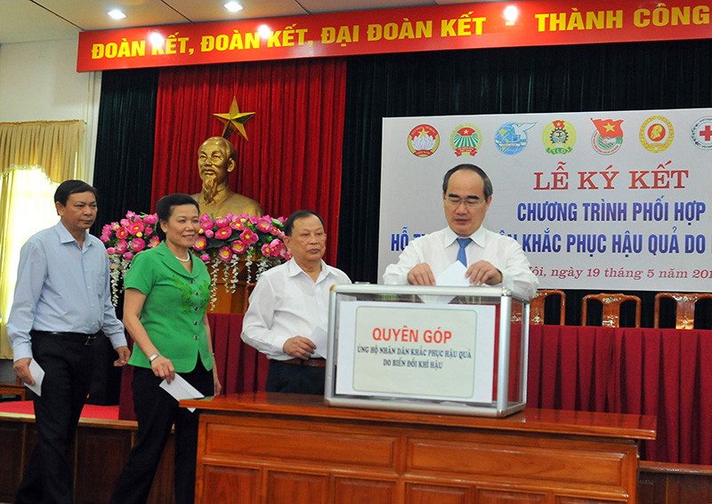 Chủ tịch Ủy ban Trung ương MTTQ Việt Nam Nguyễn Thiện Nhân và các đại biểu thực hiện hỗ trợ bà con nông dân, ngư dân. Ảnh: VGP/Hoàng Long