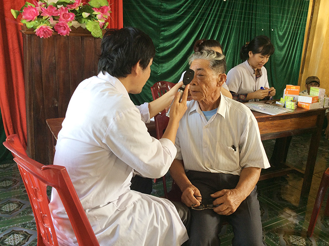 Cán bộ y tế đang thực hiện khám, cấp thuốc, tư vấn sức khỏe tại cộng đồng cho người dân.