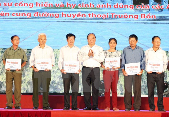 Thủ tướng Nguyễn Xuân Phúc trao sổ tiết kiệm và tặng quà cho thân nhân 13 liệt sỹ thanh niên xung phong Truông Bồn. (Ảnh: Thống Nhất/TTXVN)