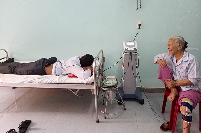 Bệnh nhân bị thoái hóa cột sống lưng và đau thần kinh tọa điều trị bằng máy điện xung.