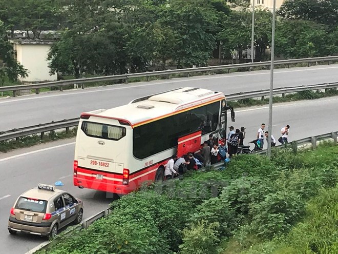 Nhà xe trả khách sai quy định ngay tại nút giao vòng lên đường vành đai 3 trên cao. (Ảnh: Việt Hùng/Vietnam+)